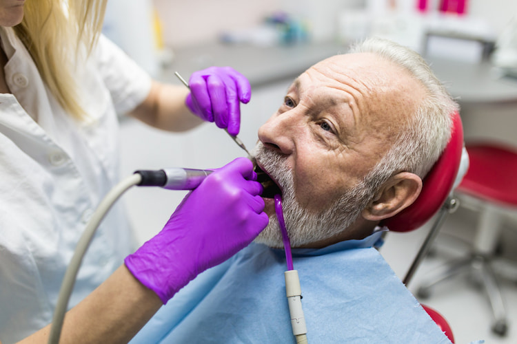 an old man is receiving a dental treatment under the CDCP coverage.