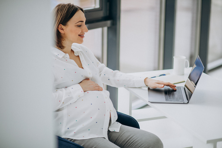 a pregnant woman using a laptop to check her eligibility for the CDCP.